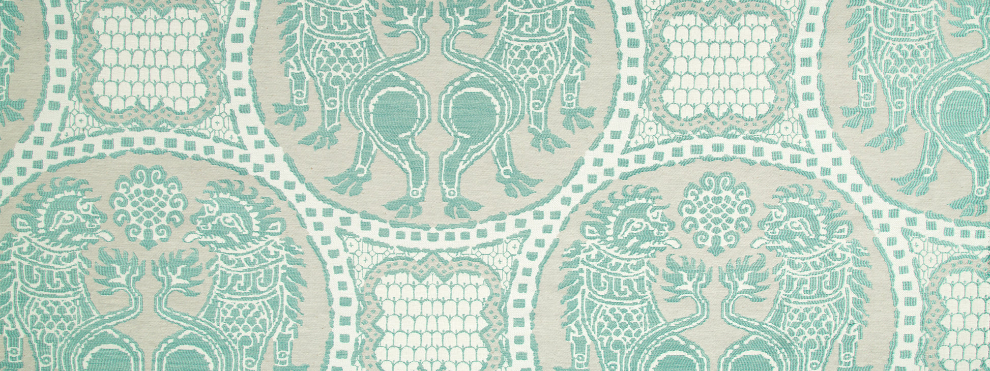 Teal damask-style upholstery fabric pattern with ornate medallions, vines and scrollwork on a light beige background.