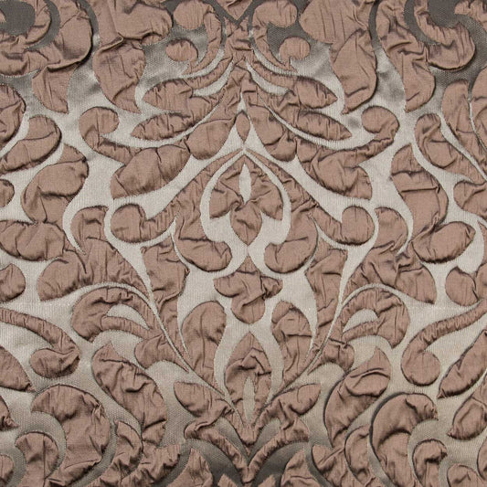 Brown damask velvet jacquard fabric with raised scrolling leaf pattern on beige background, decorative upholstery textile.