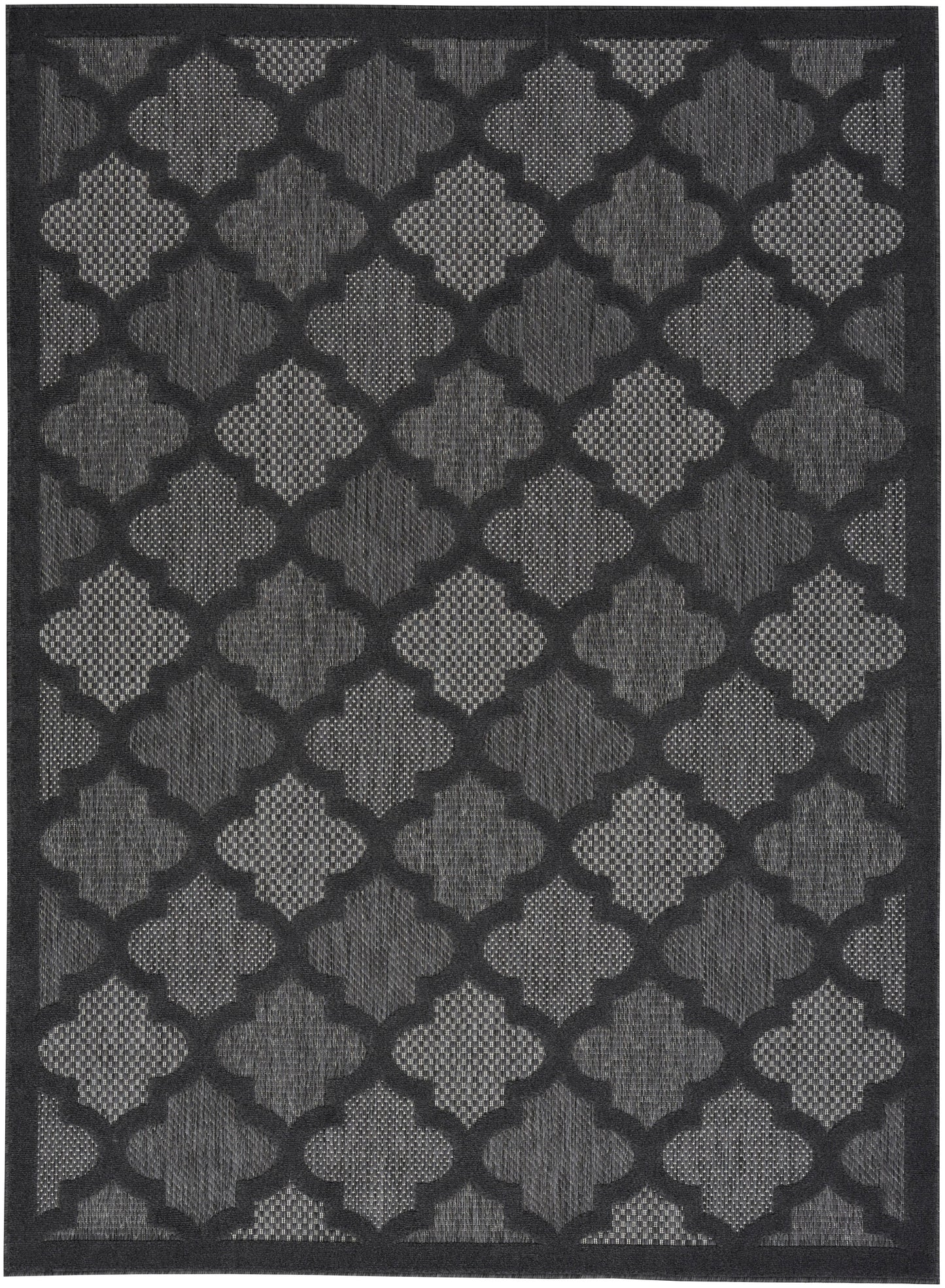Rectangular rug in dark gray tones with a repeating quatrefoil lattice pattern and textured weave.