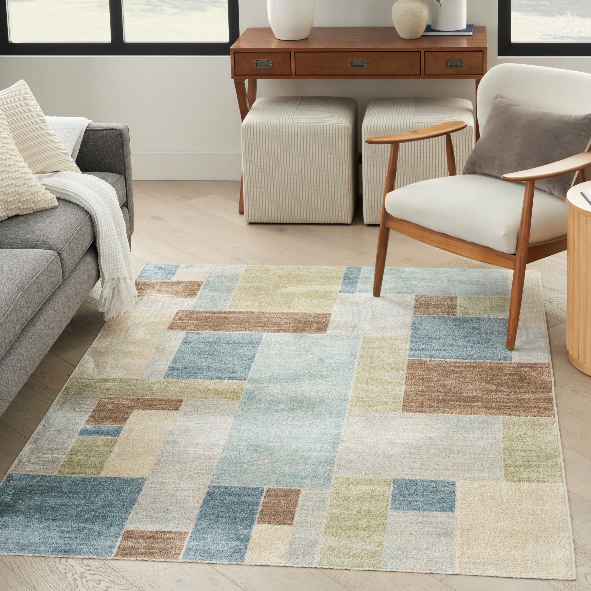 Pastel geometric area rug with rectangular color blocks in blue, beige, brown & sage; soft woven texture.