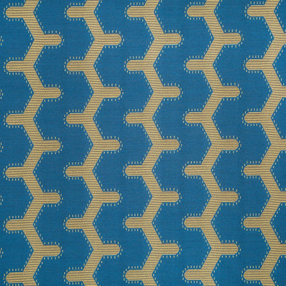 Blue woven fabric with repeating beige zigzag chain pattern; geometric chevron upholstery textile.