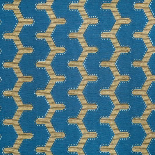 Blue woven fabric with repeating beige zigzag chain pattern; geometric chevron upholstery textile.