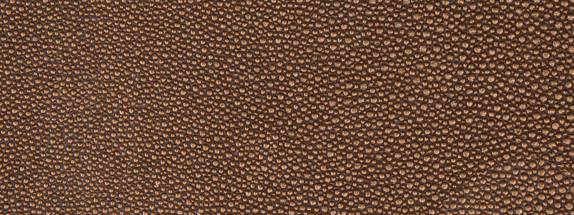 Brown pebbled fabric texture close-up, upholstery fabric with a leather-like grain.