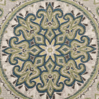 Circular mandala pattern with teal-green scrolls on beige textured fabric pillow.