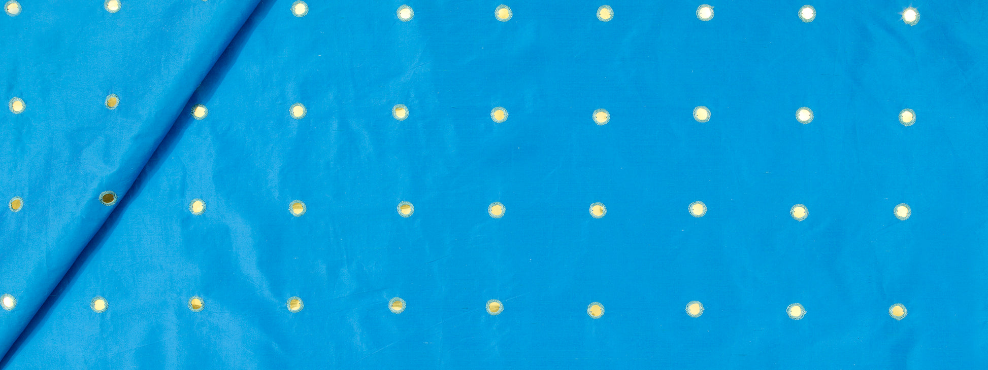 Bright blue fabric with evenly spaced small yellow polka dots; smooth textile.