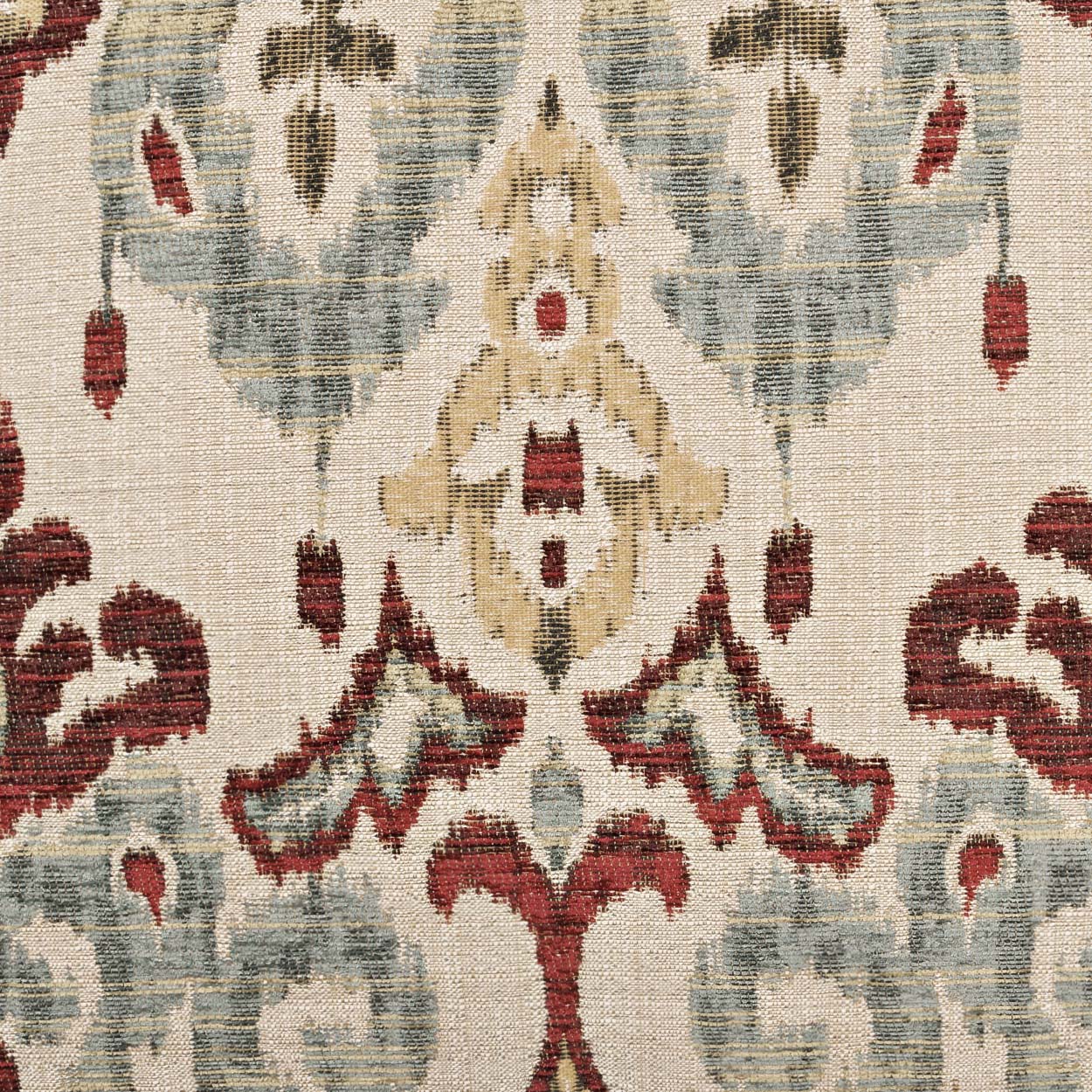 Beige woven pillow with damask-inspired red and pale blue floral arabesque pattern.