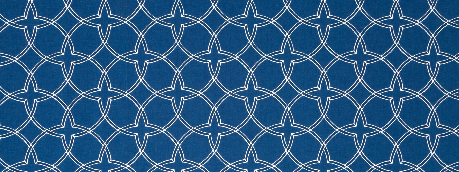 Indigo fabric with white interlocking circular lattice pattern; decorative geometric repeat.