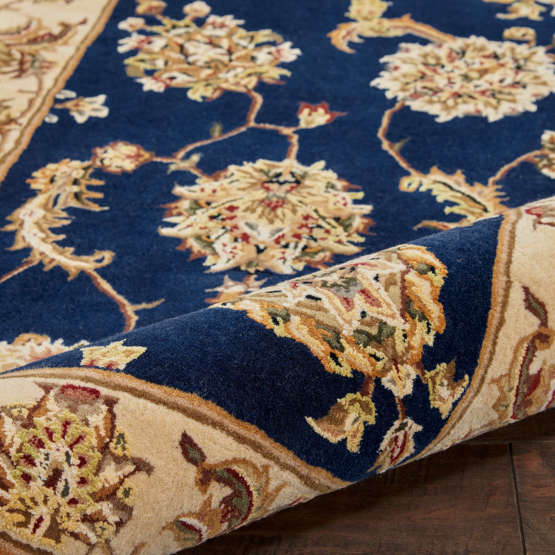 Deep blue oriental rug with cream-gold floral medallions and beige border, traditional Persian motif.