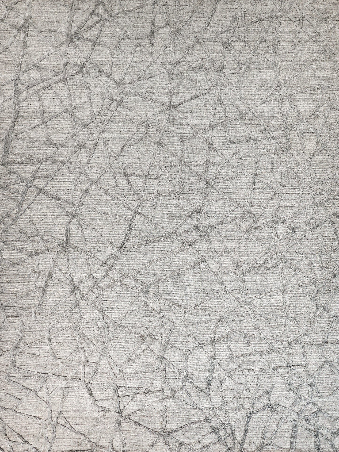 Abstract gray twig-like lines on beige woven rug; modern, soft textured area rug.