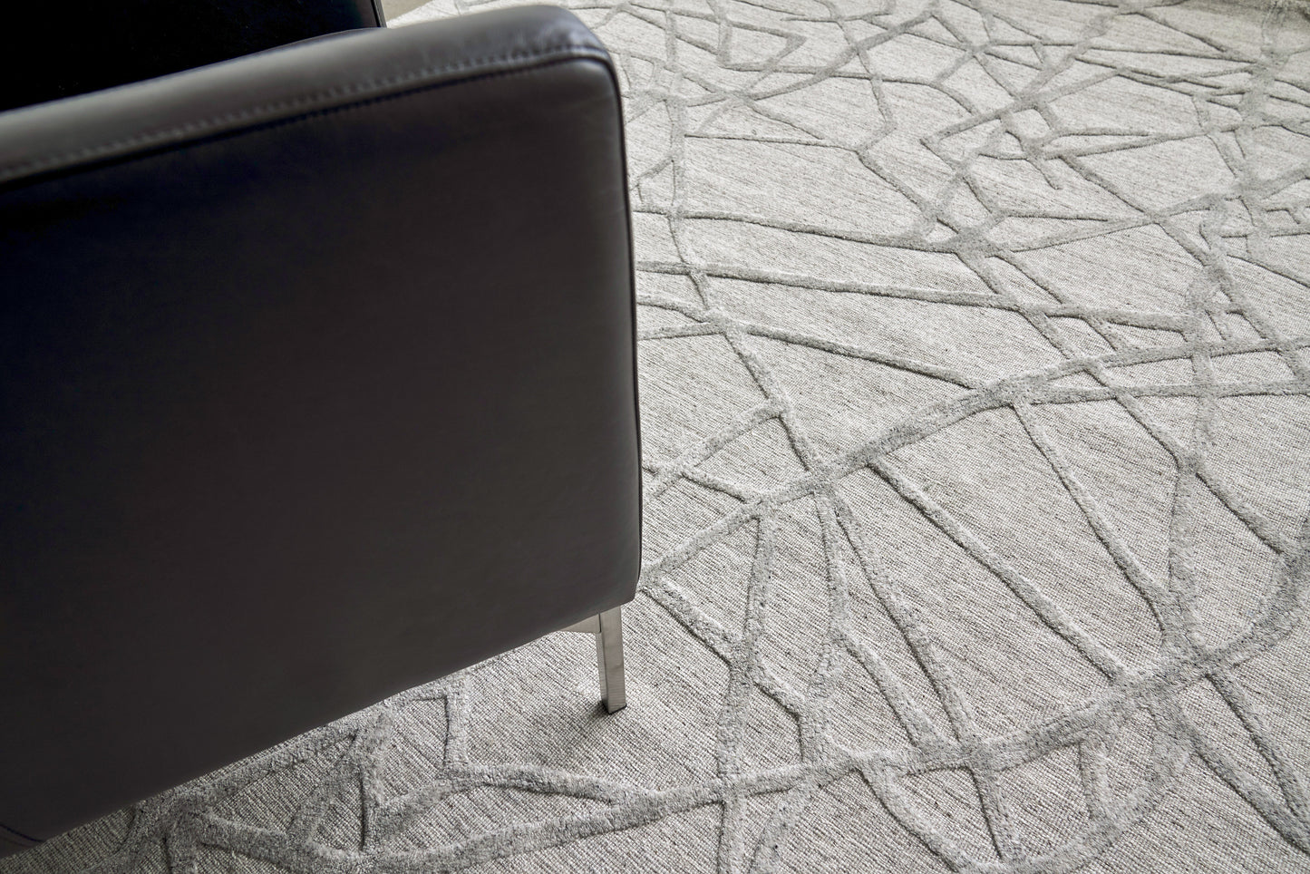 Grey geometric patterned rug with woven texture.