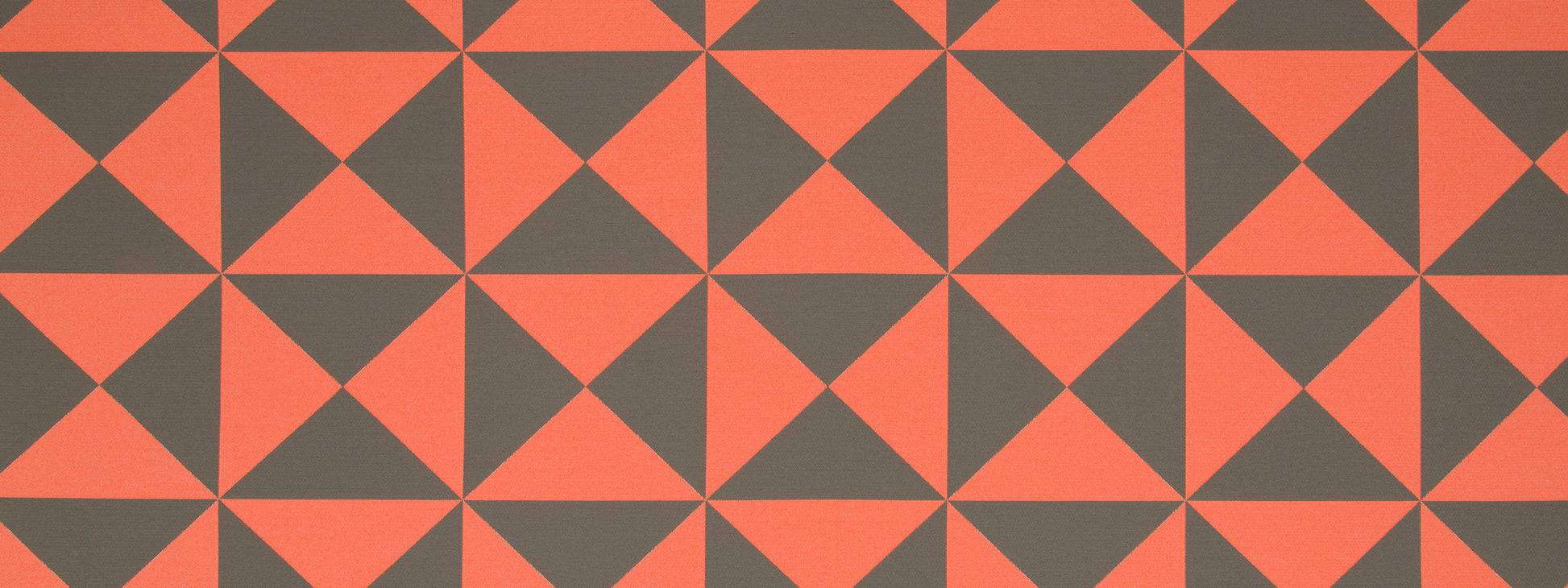 Orange and charcoal gray geometric pinwheel pattern of tessellated triangles; bold modern textile or wallpaper design.