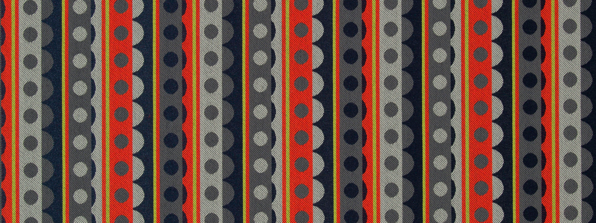 Geometric striped fabric design with vertical rows of circles in red, navy, gray and black; bold retro textile.