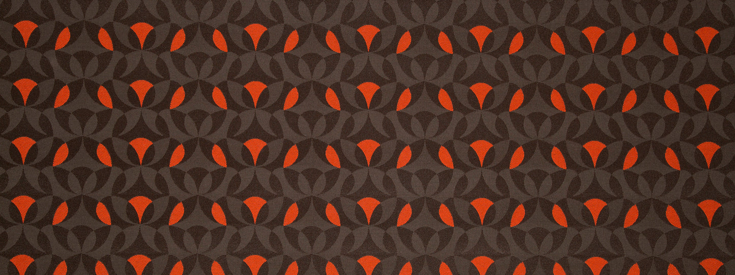 Dark charcoal gray background with an orange interlocking circular pattern; bold geometric upholstery fabric.