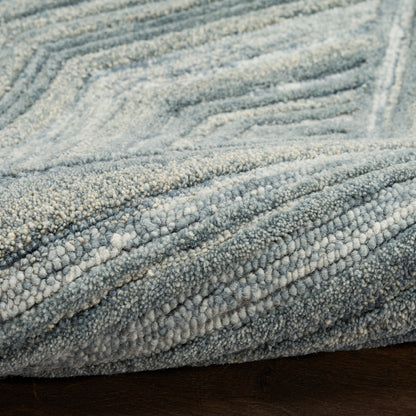 Blue-gray textured shag rug with dense loop pile and subtle chevron pattern for cozy living room decor.