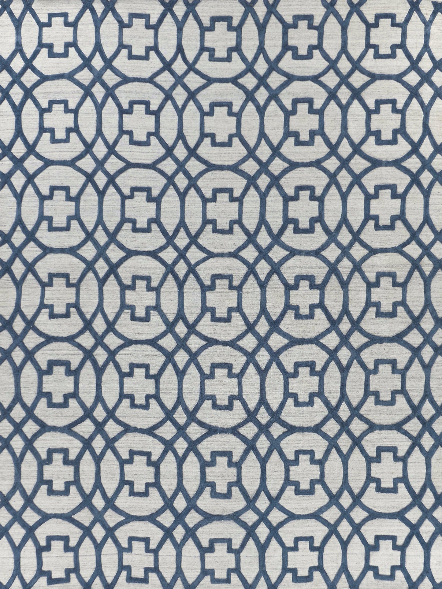 Navy blue geometric lattice on light gray rug, interlocking circles with square centers; modern rug print.