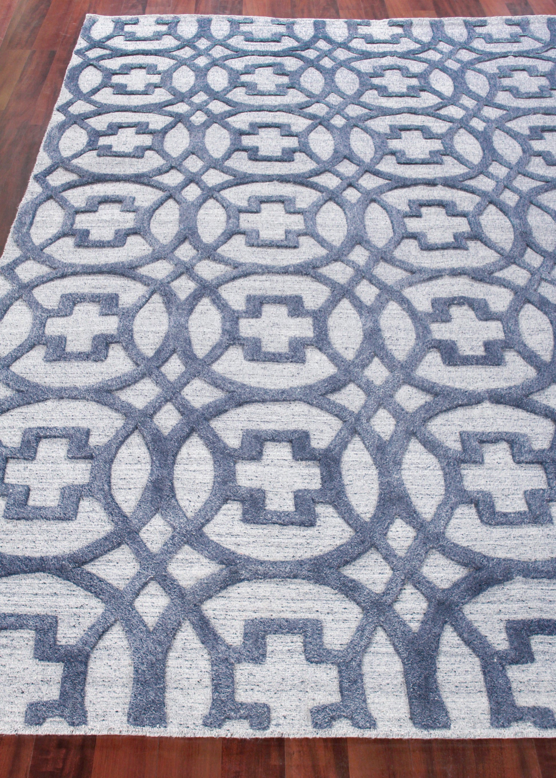 Blue and light gray geometric woven rug with interlocking ring lattice pattern, ideal for living spaces.