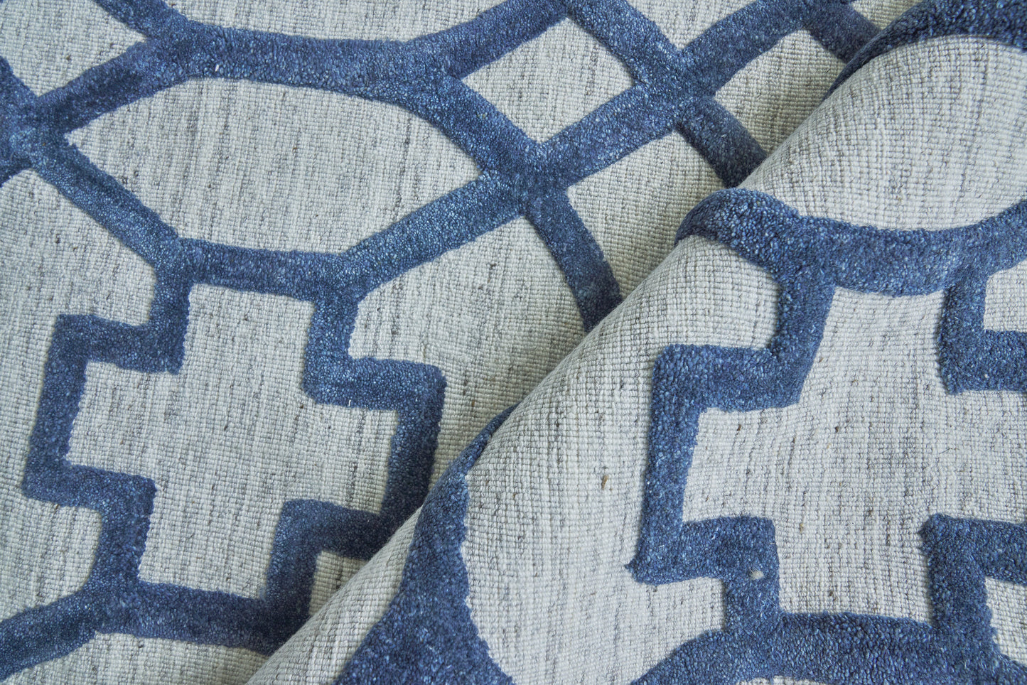 Cream rug with blue geometric lattice pattern, 12' x 15'.