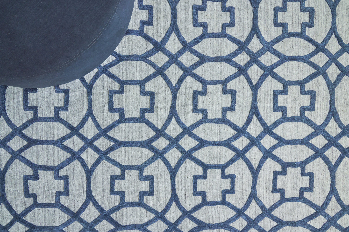 Light blue rug with a navy geometric interlocking circle pattern.