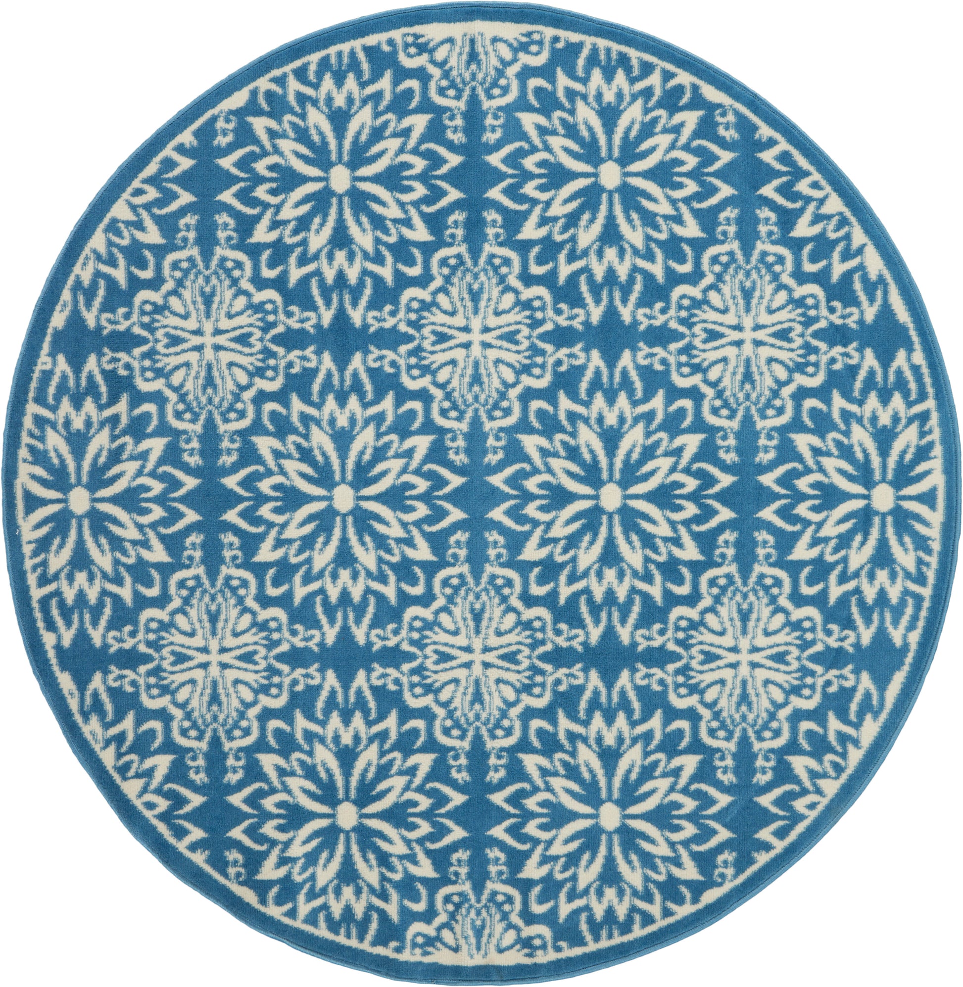 Round blue rug with white intricate floral snowflake motif and teal border.