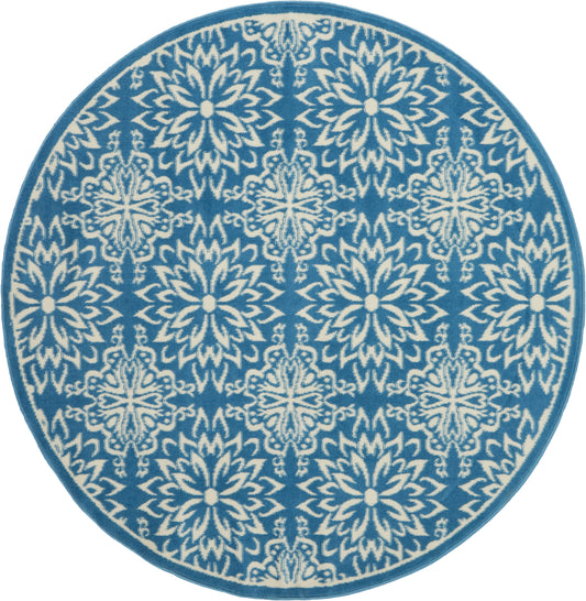 Round blue rug with white intricate floral snowflake motif and teal border.