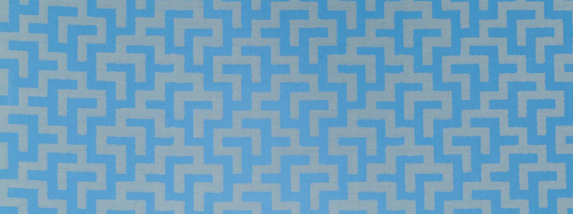 Blue and light-blue geometric maze pattern fabric with interlocking zigzag shapes, modern textile design.