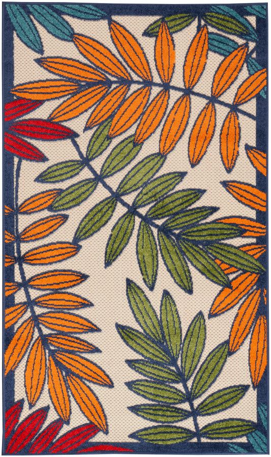 Rectangular textured rug with bold tropical leaves in orange, green, and red on beige, edged in navy