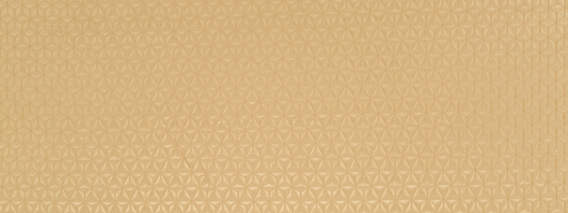 Golden beige textured drapery fabric with a subtle repeating geometric floral pattern and metallic sheen.