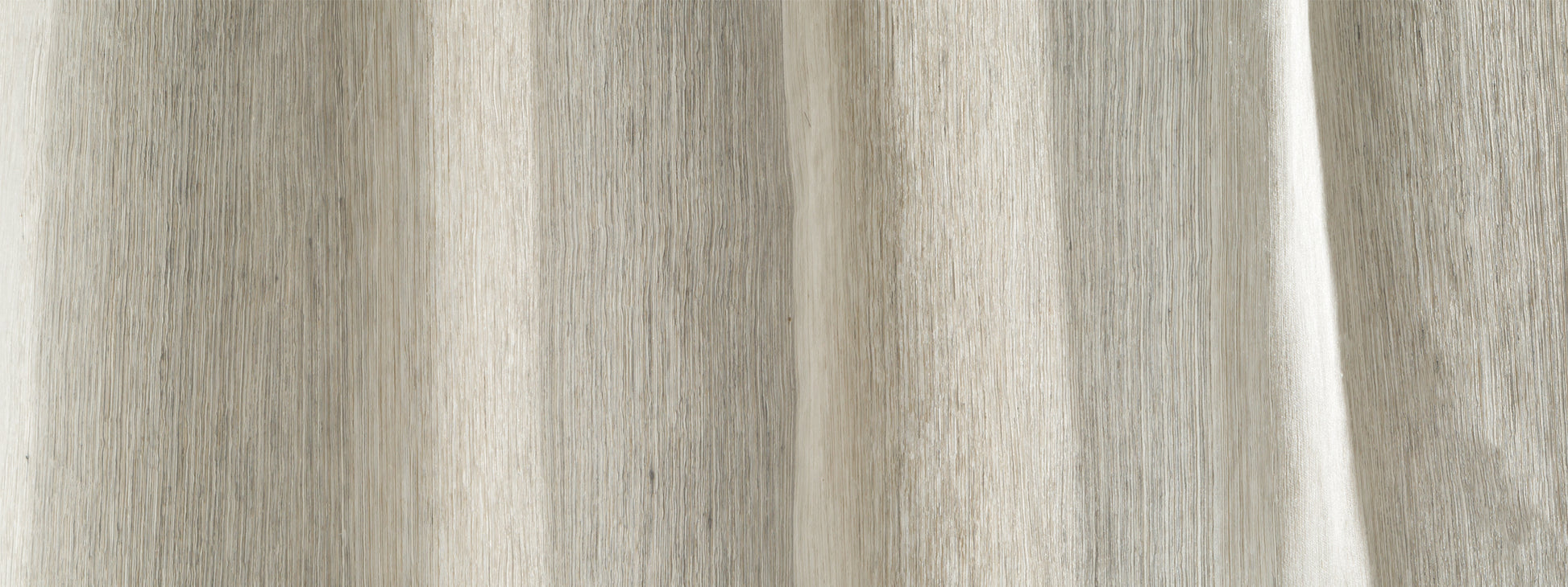 Close-up of light beige linen curtain fabric with vertical folds, drapery panel for window use.