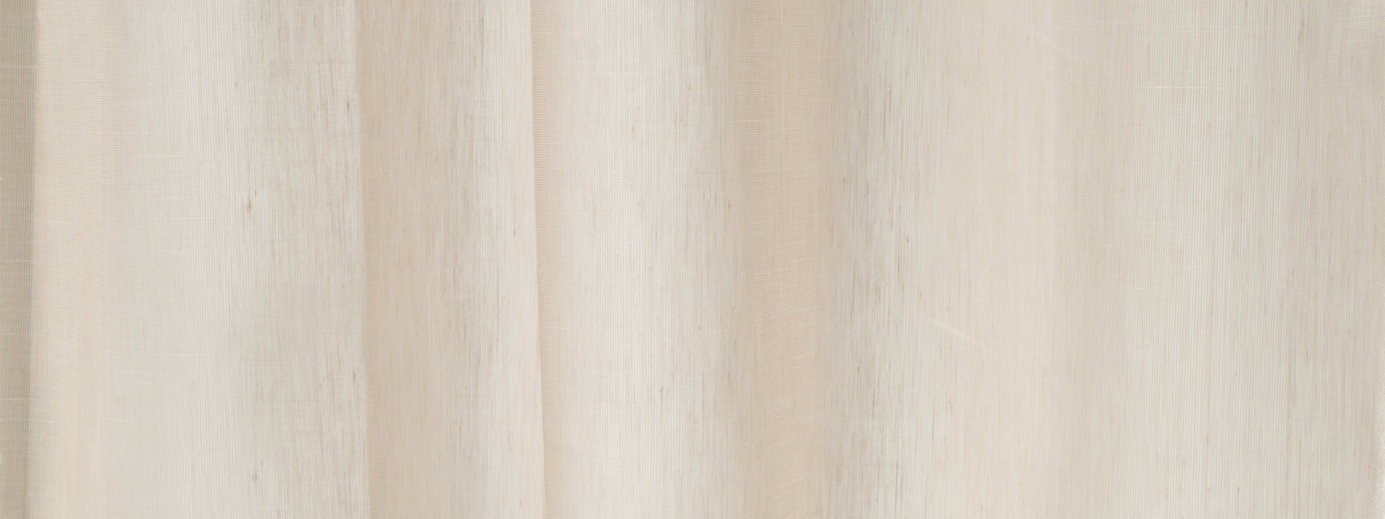Cream-beige curtain fabric with soft vertical folds; neutral window drape for living spaces.