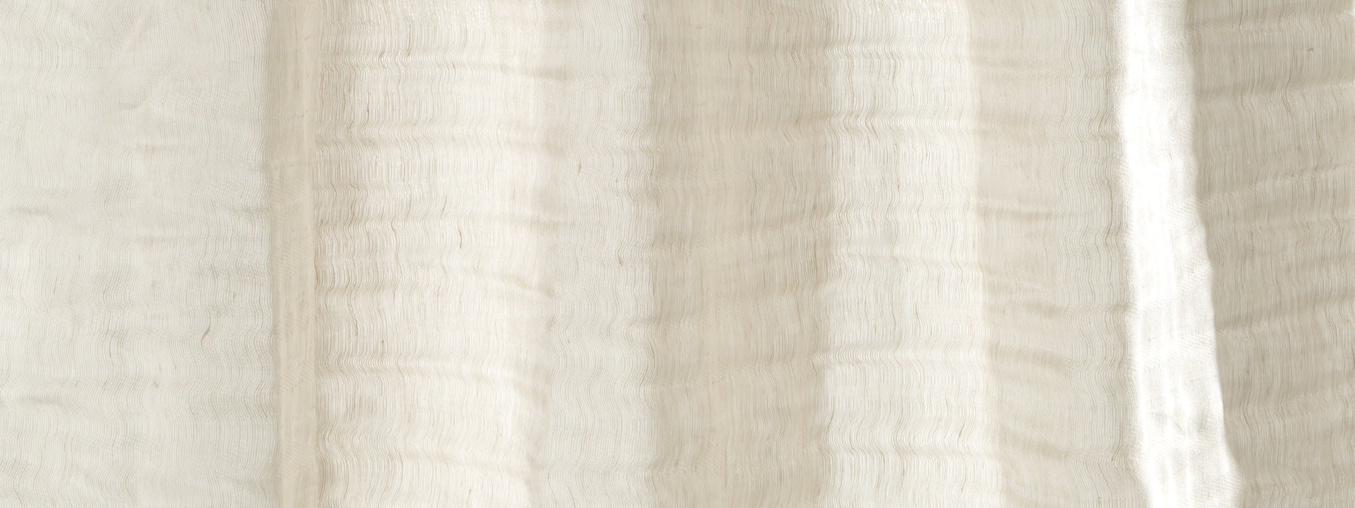 Cream linen-style fabric close-up with ribbed texture and soft folds.