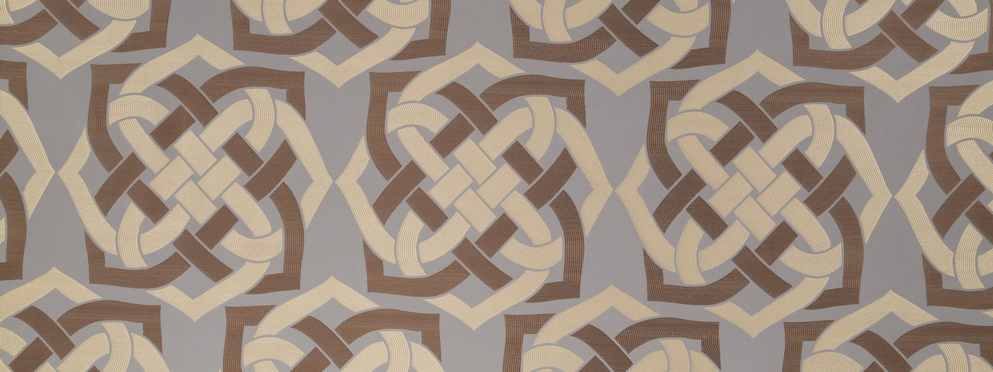 Beige and brown geometric knot motif on muted gray background; a textile or wallpaper pattern.