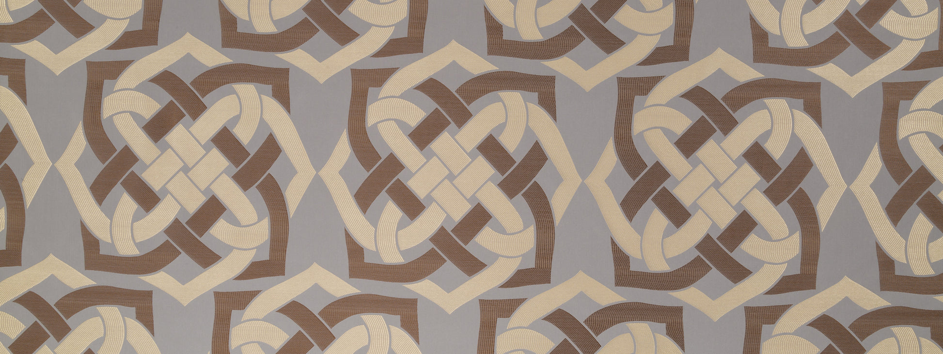 Beige and brown geometric knot motif on muted gray background; a textile or wallpaper pattern.