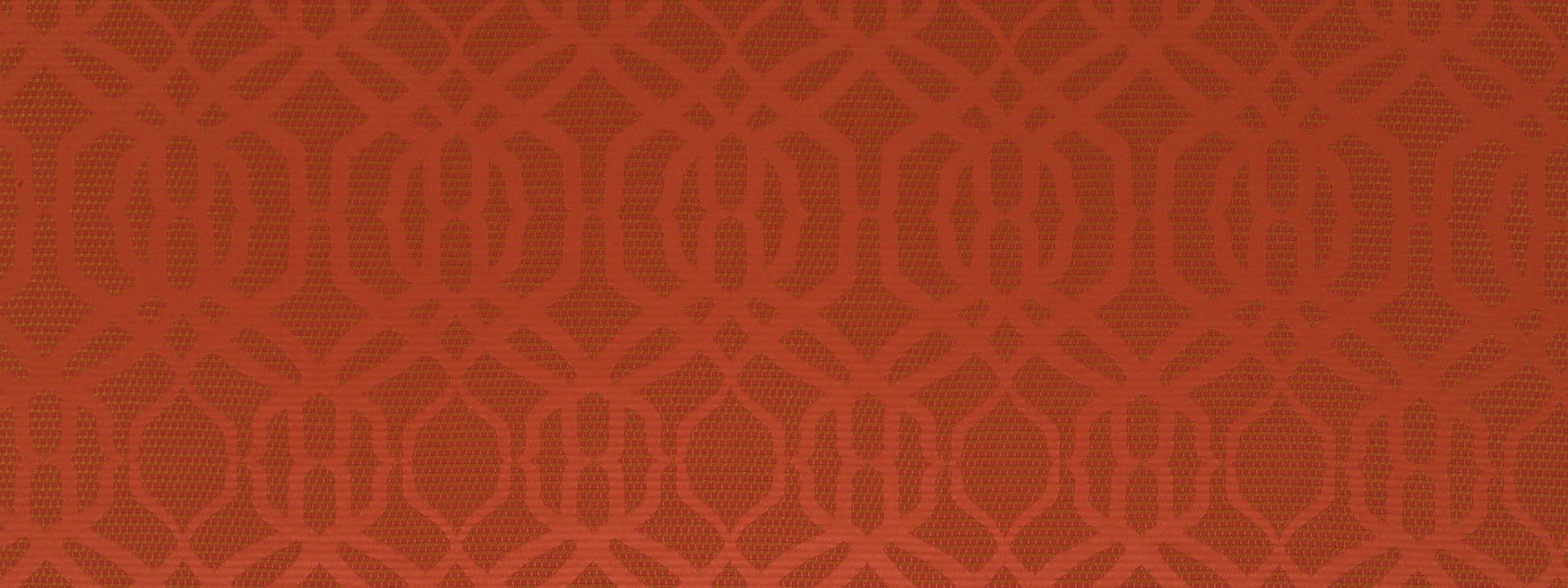 Close-up of burnt orange upholstery fabric with a repeating interlocking circular motif; textured textile.
