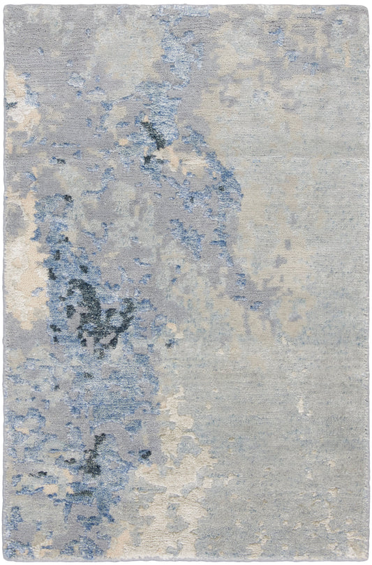 Rectangular area rug with abstract blue-gray pattern in ivory and pale blue; soft plush pile for living spaces.