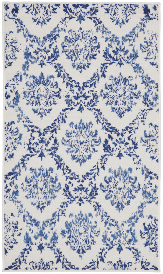 Blue damask-on-white area rug with repeated floral medallions; traditional decorative rug.