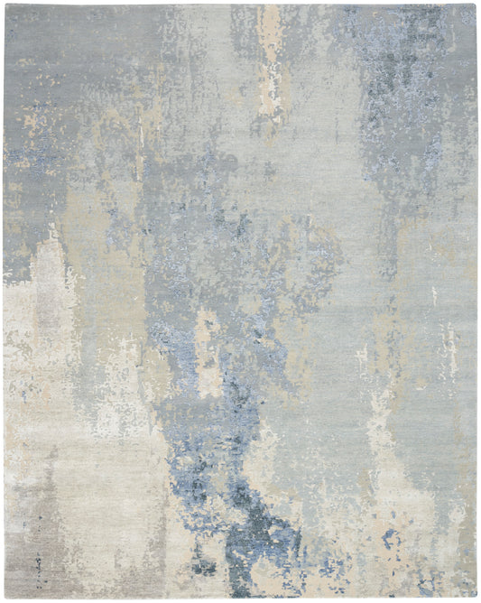 Rectangular abstract area rug in muted blue, gray and beige with a distressed print; plush pile.