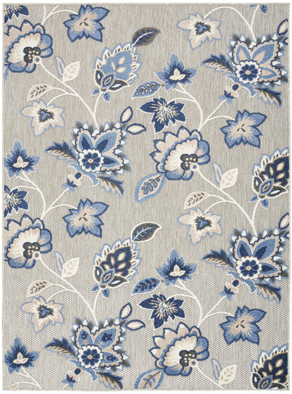 Area rug with blue floral motifs on beige background; navy, light blue & white flowers with white stems.