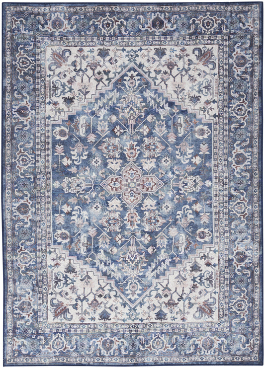 Blue-toned Persian-style area rug with ivory floral medallion and ornate border, distressed vintage look.