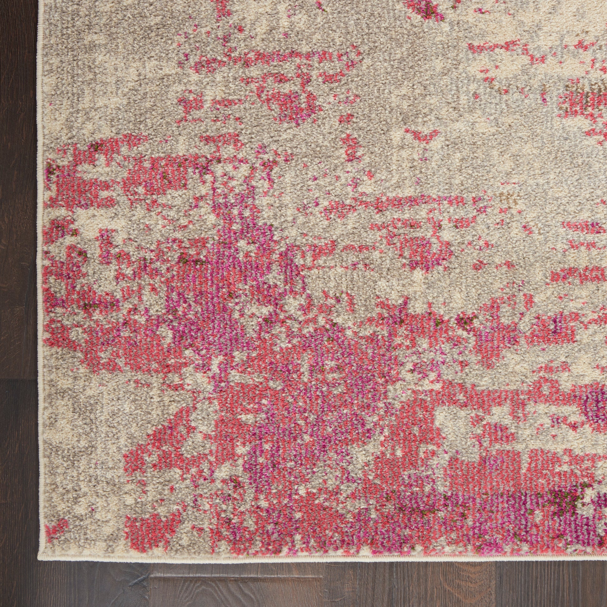 Beige abstract area rug with pink magenta splotches; modern, textured look; edge visible.