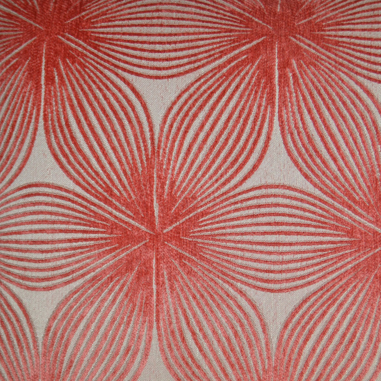 Red concentric petal floral pattern on cream fabric; bold retro textile for upholstery or drapes.