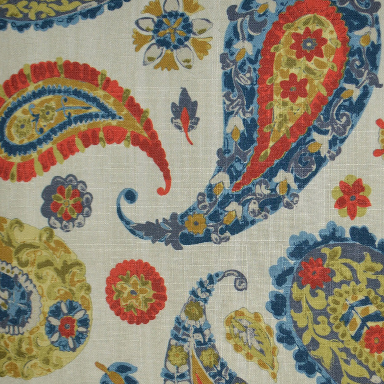 Vibrant paisley and floral fabric pattern with red, blue & gold on a light background.