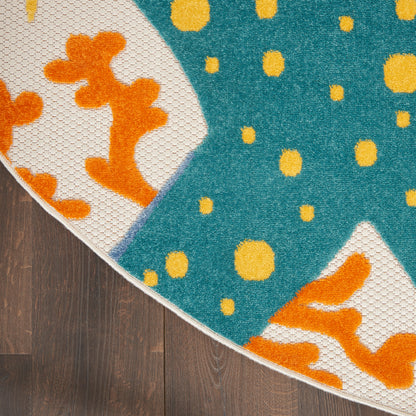 Round rug with teal field and yellow dots; white curved panels with orange coral shapes, fringe on dark wood floor.