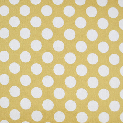 Mustard-yellow pillow with white polka dots; retro style.
