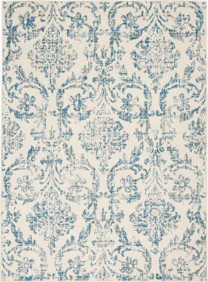 Rectangular area rug with blue damask motifs on cream background, distressed vintage look.