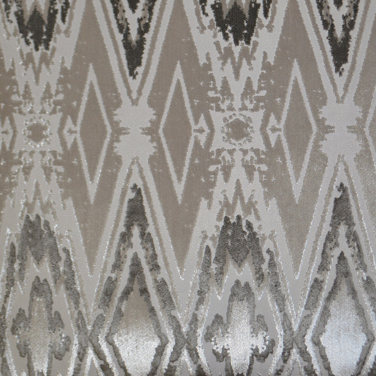 Neutral beige-gray ikat fabric with diamond motifs; versatile textile for upholstery or drapery.