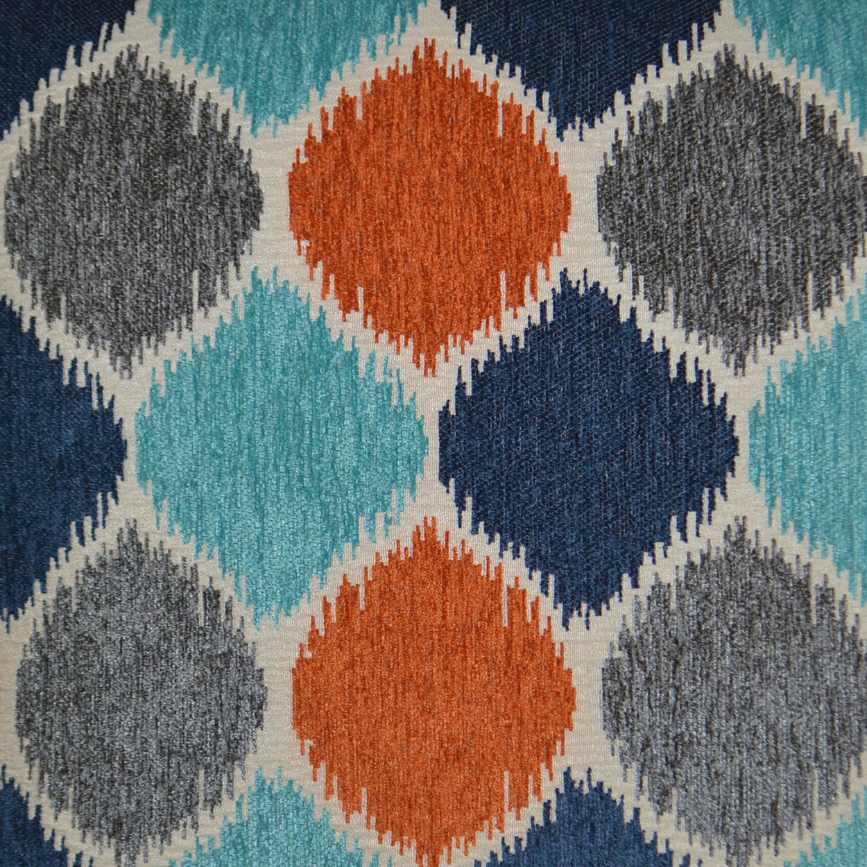 Pillow with a woven textile featuring a bold diamond lattice in teal, orange, navy and gray.