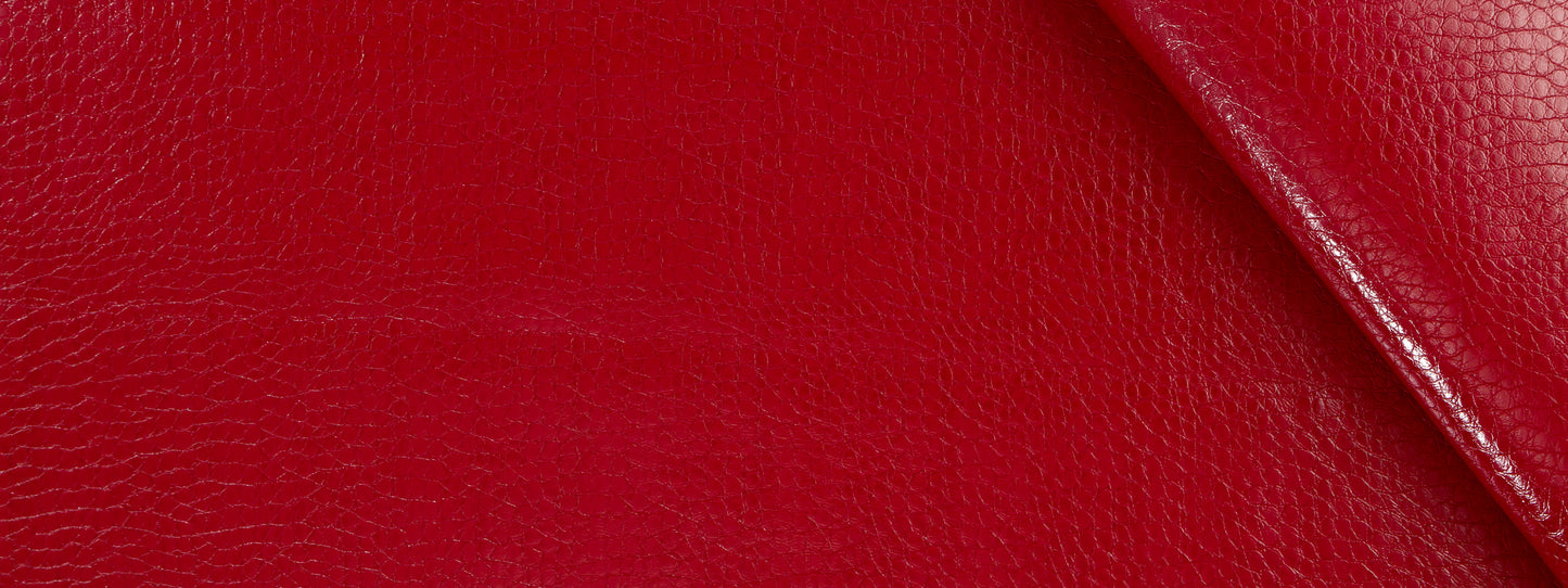 Close-up red crocodile-textured upholstery with a diagonal stitched edge.