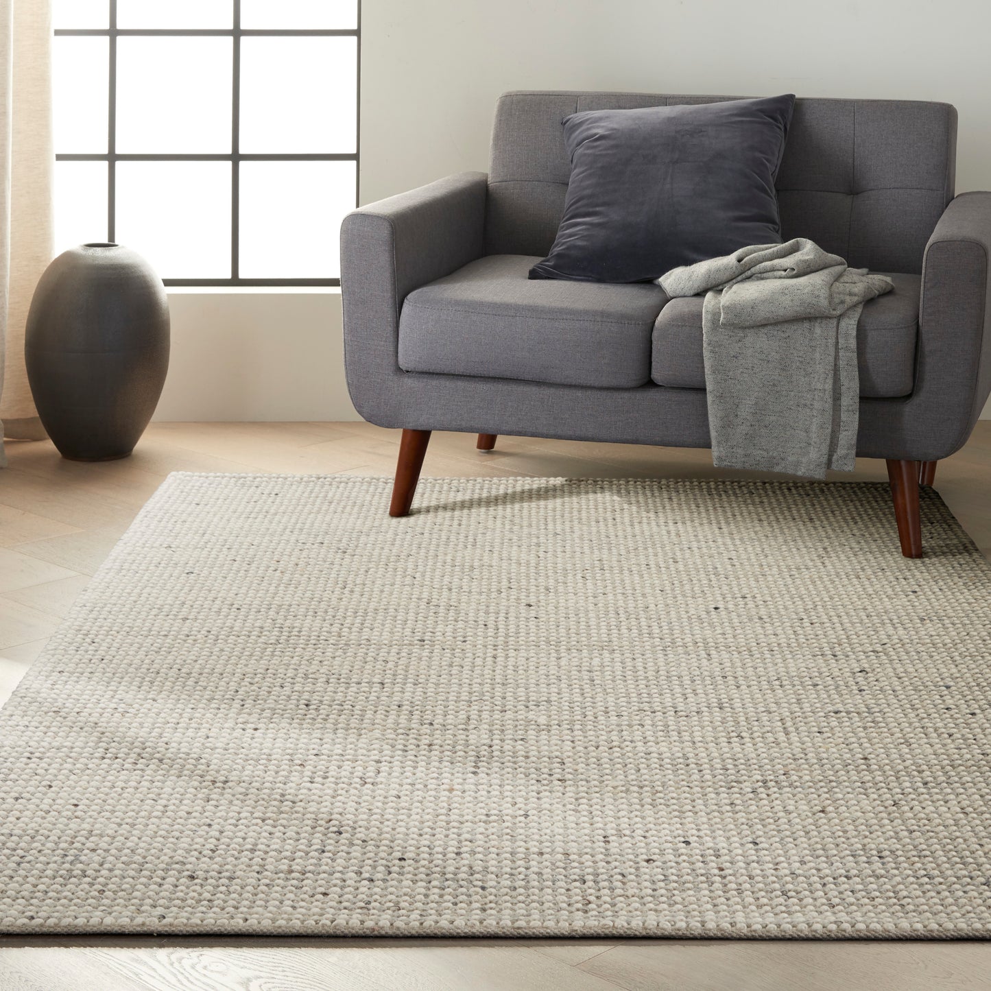 Beige woven rug in a bright living room, measuring 5' x 7'.