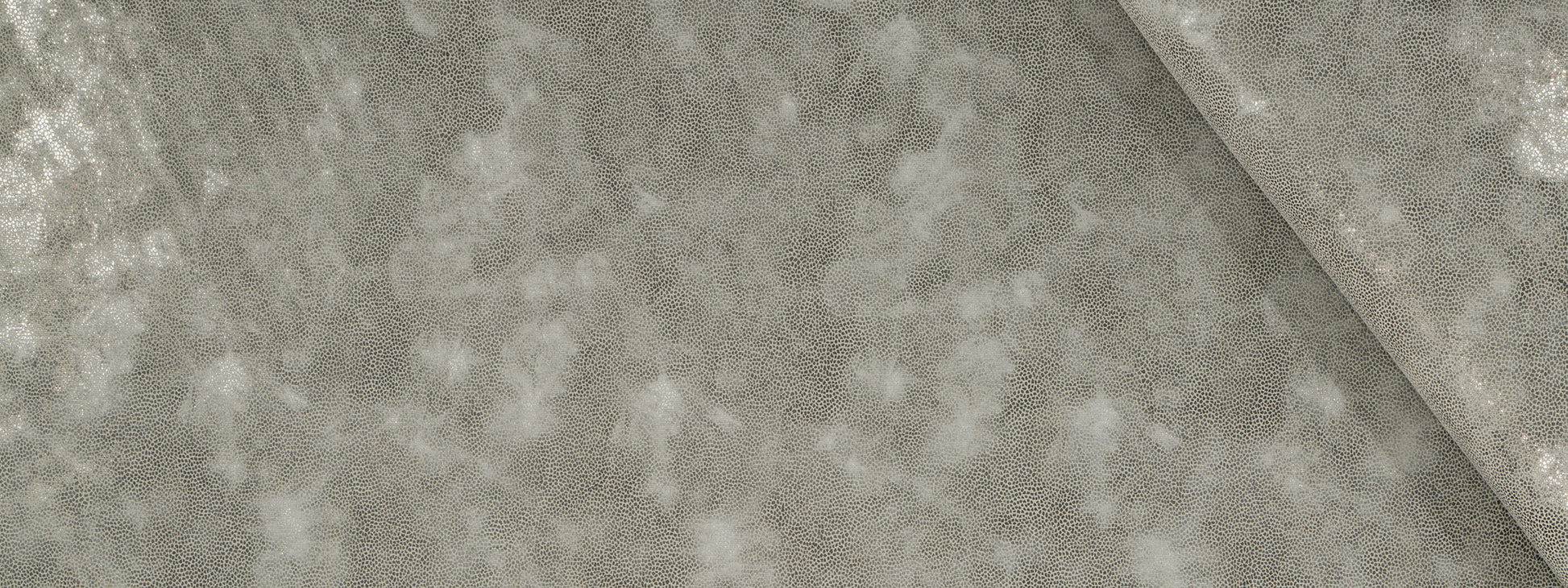 Grey crushed velvet upholstery fabric close-up with a diagonal fold, soft luxurious texture.