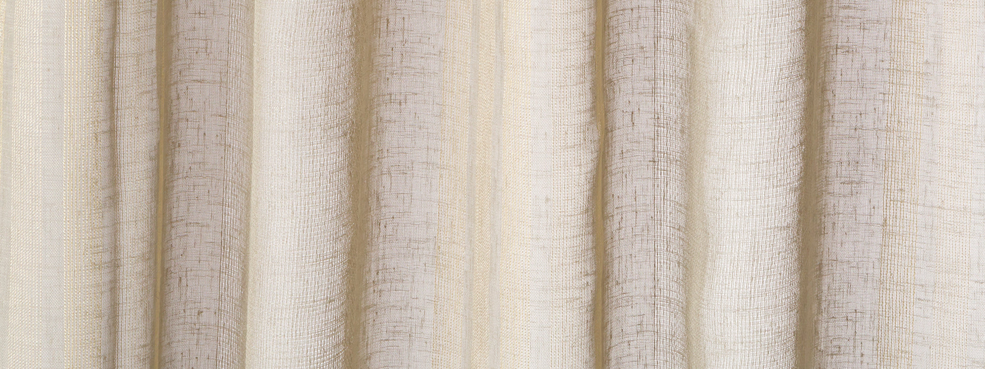 Cream-beige curtains with a textured weave, vertical folds, and the Skip Stripe pattern.